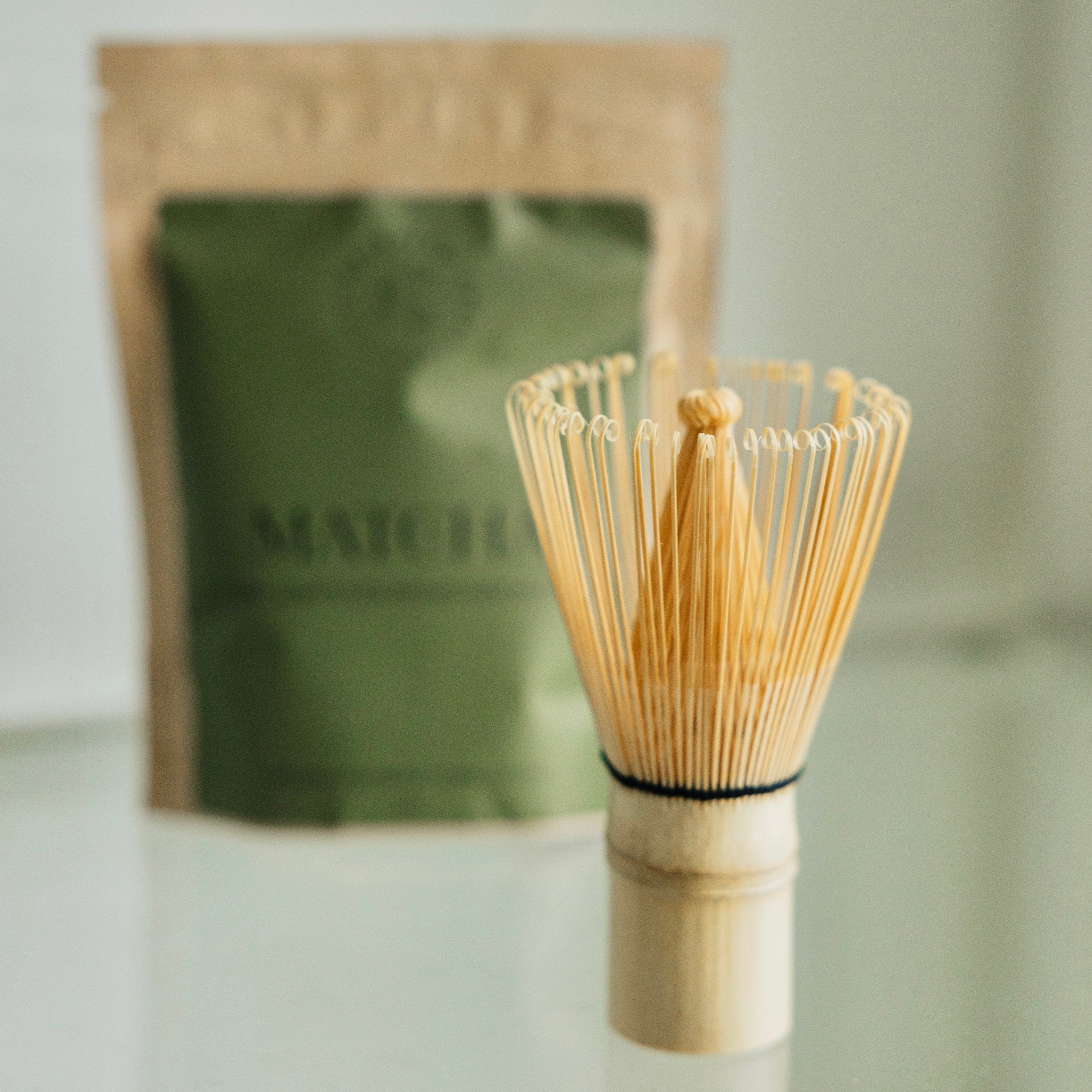 Matcha whisk with daydream Organics matcha in the background