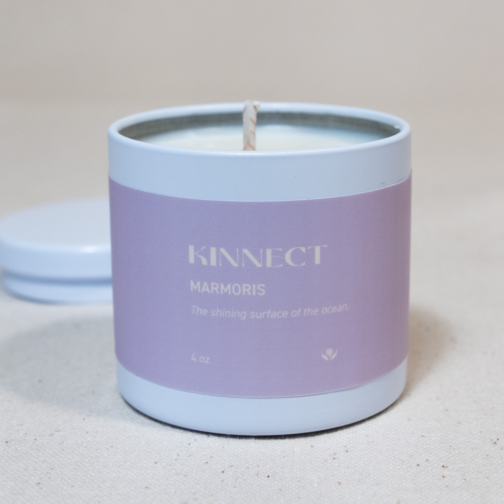 Kinnect marmoris candle in a white container with 'KINNECT' branding on a light background