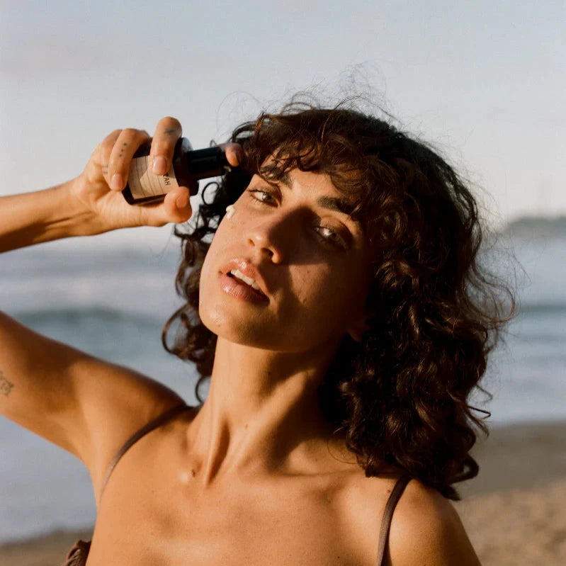 Woman applying Forah Mineral Sun Milk sunscreen on a beach