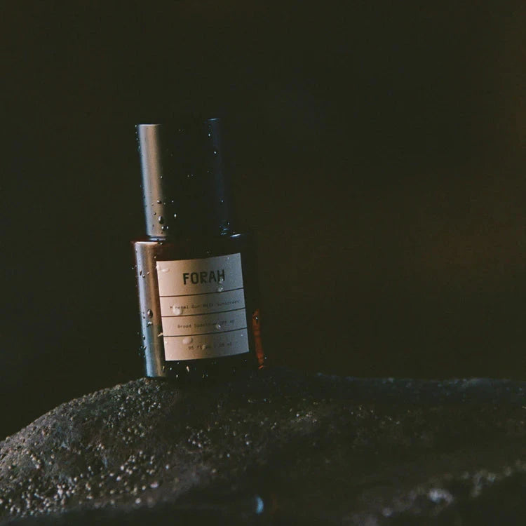 Bottle of FORAH on a dark textured surface