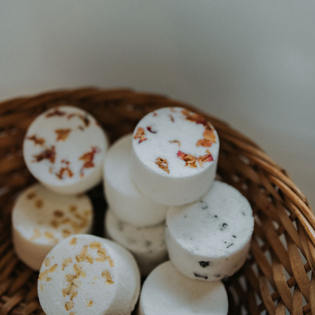 Collection of unwrapped bath bombs in wicker basket