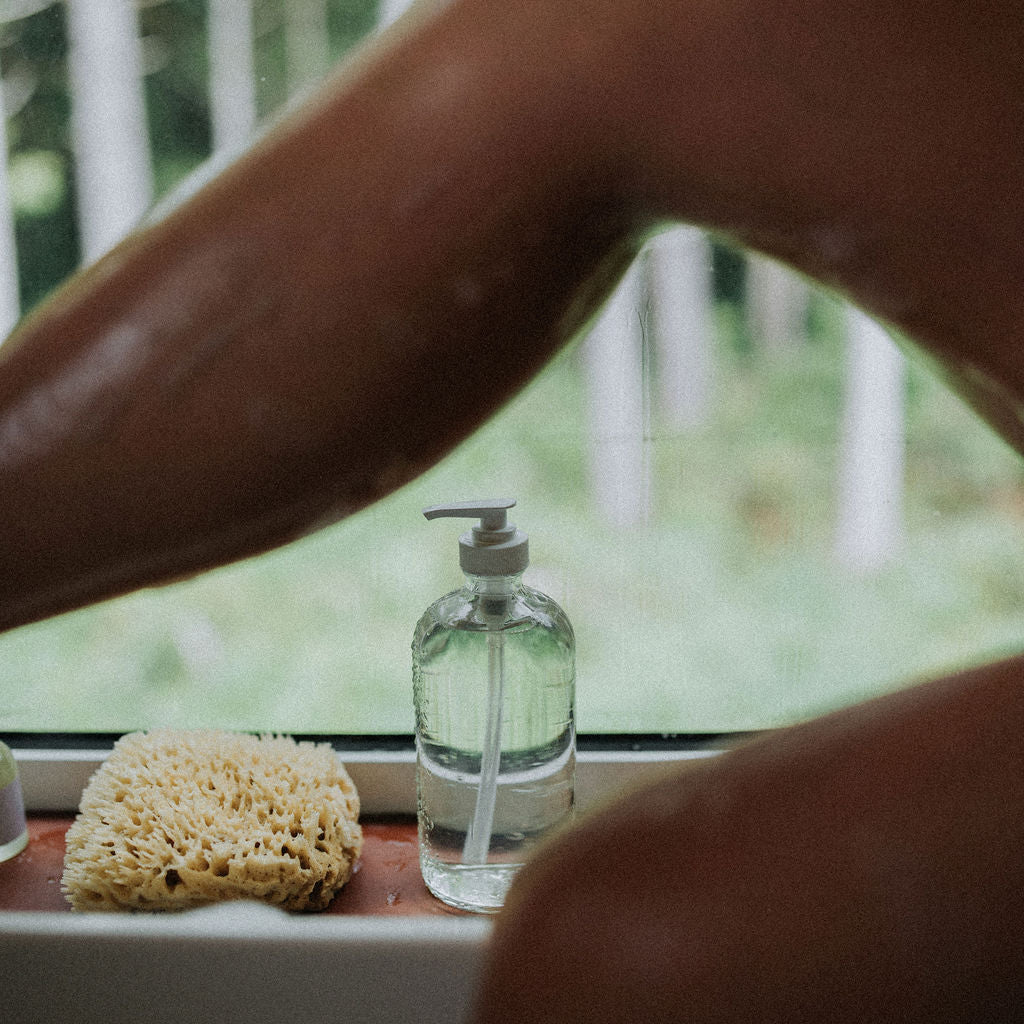 Person washing themself and a sponge on a windowsill.