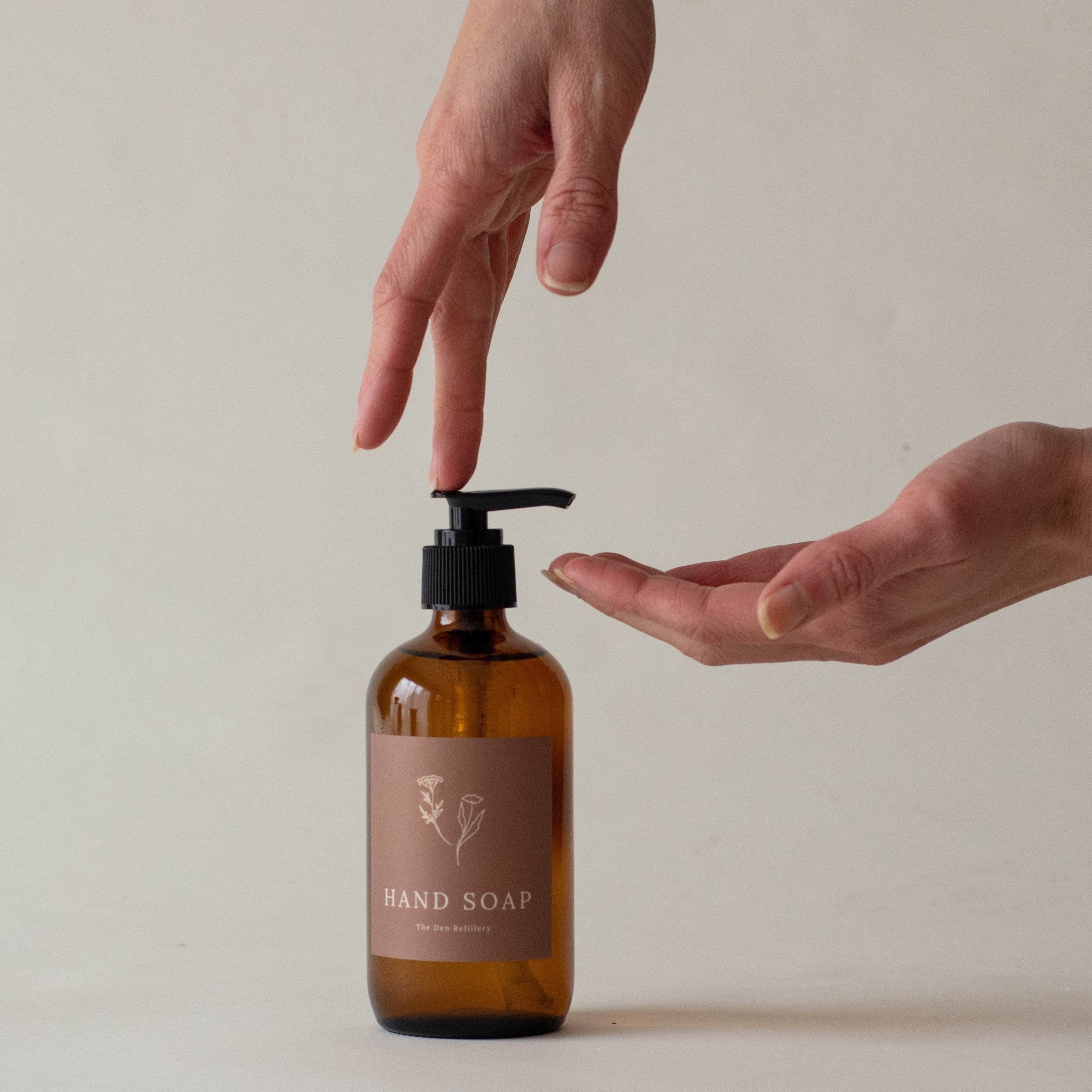 Hands pose to pump ONEKA body wash in white room