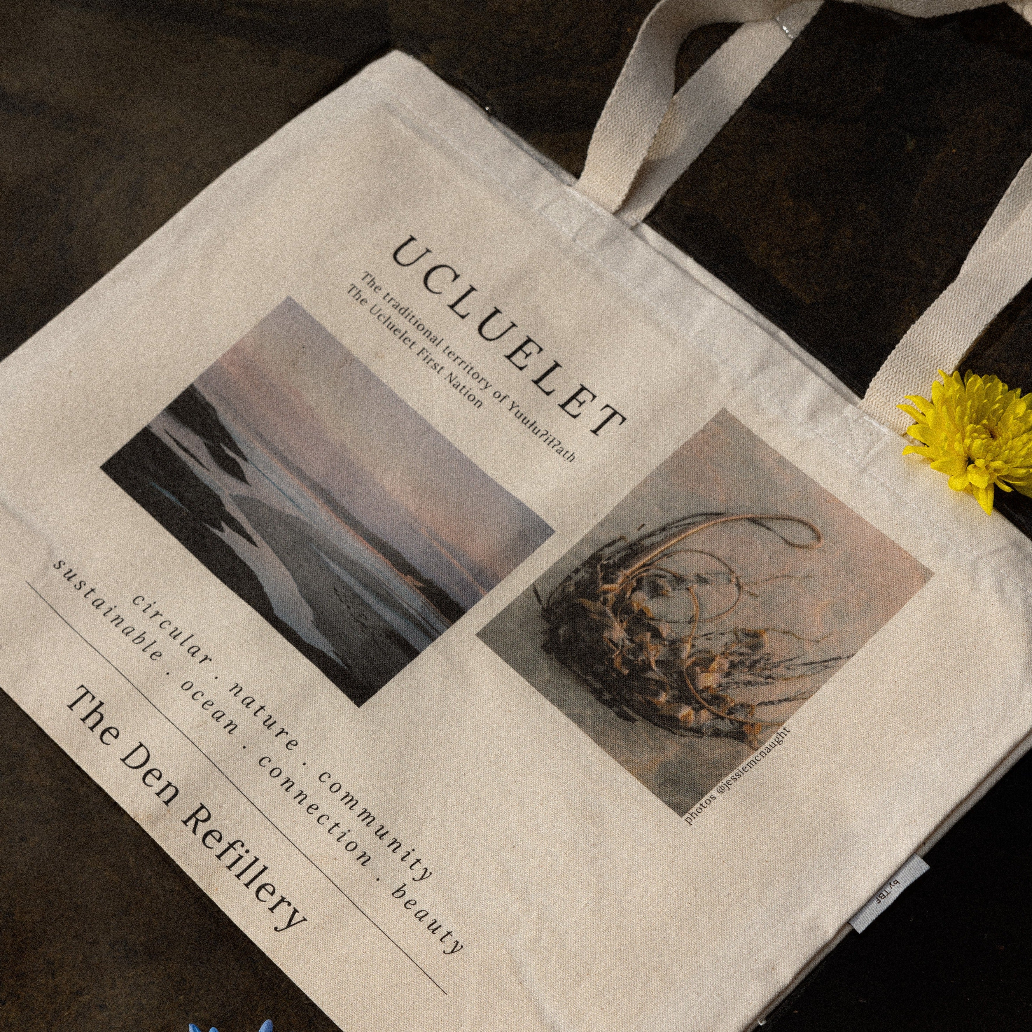 The Den Refillery Ucluelet Canvas Tote Bag with images of kelp on a beach and a beach with water trenches. Some key words on the totes are: circular, nature, community, sustainable, ocean, connection, and beauty