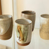 Four Kay Ceramics ceramic tumblers. Dragonfruit [front], Sand Splash [left], red antique [back], white speckle [right]