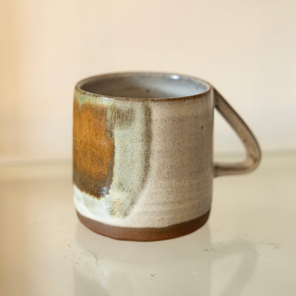 Kay ceramics elbow mug with dragonfruit glaze. The dragon fruit glaze features beautiful streaks of browns and greens over a white base