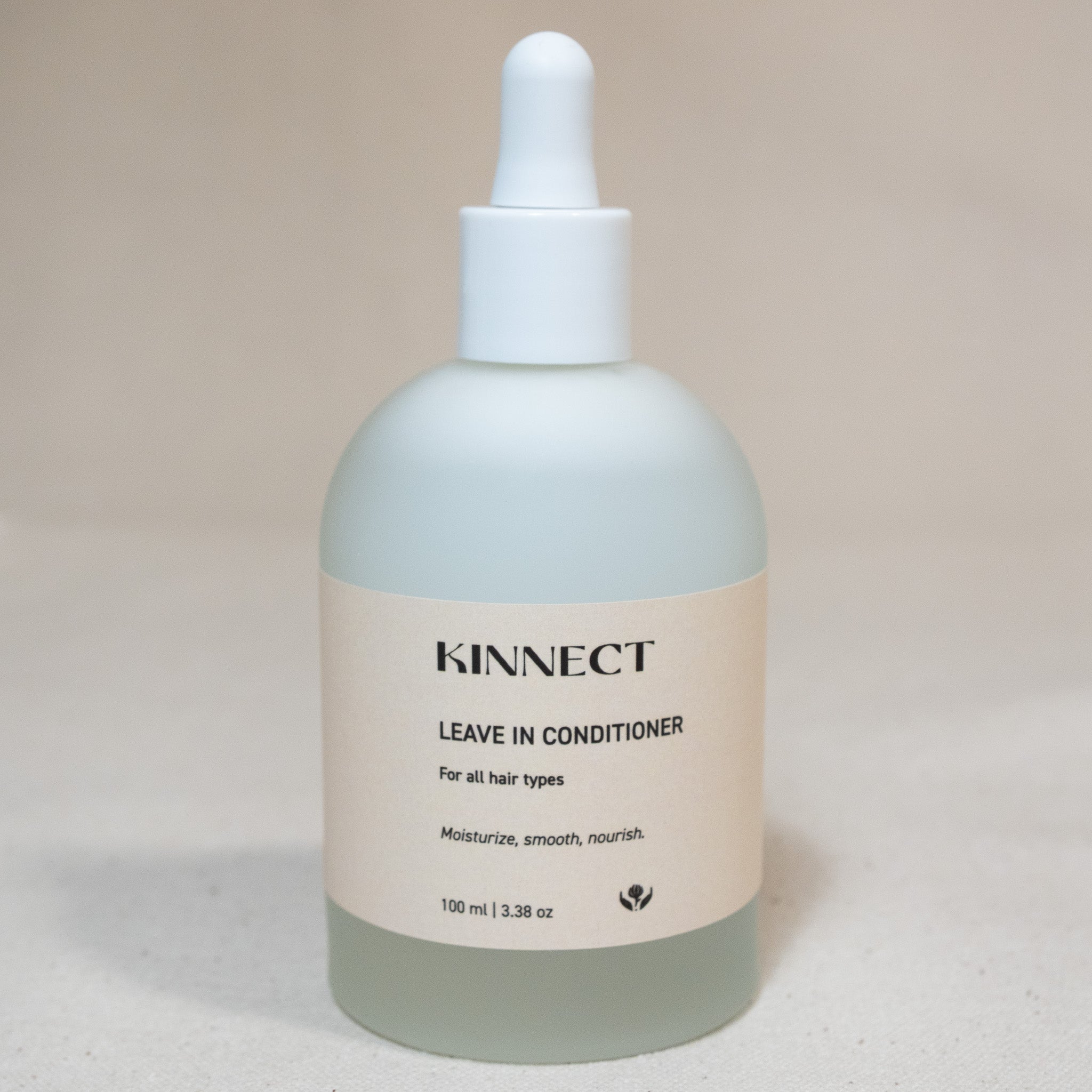 Kinnect leave-in conditioner bottle on a beige background