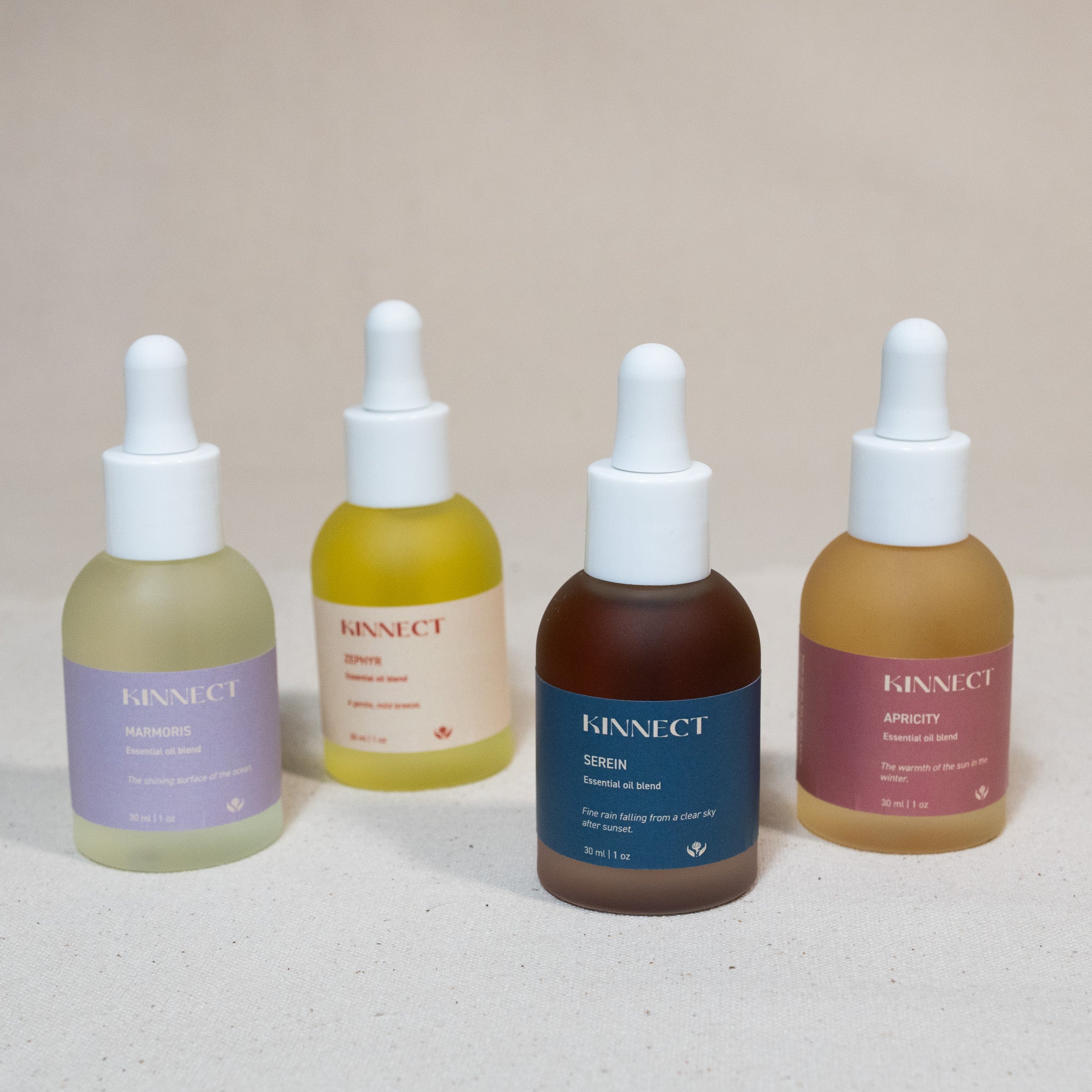 Four Kinnect essential oil blend dropper bottles with different colored liquids and labels on a light background