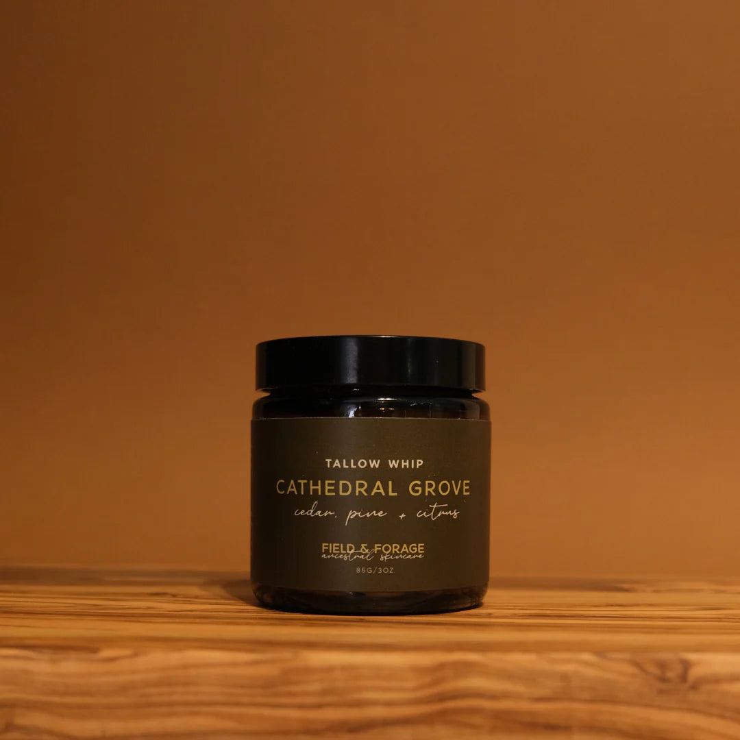 Jar of 'Cathedral Grove' tallow whip on a wooden surface with a brown background