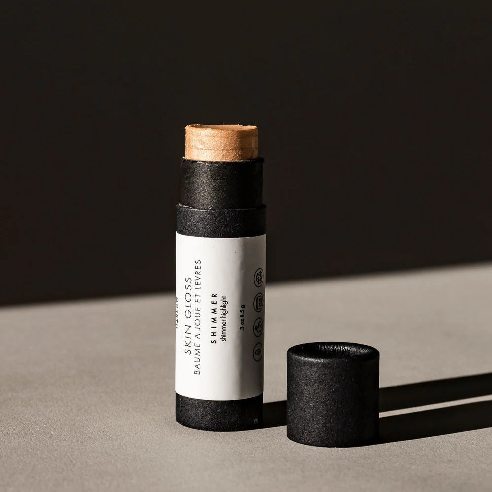 Black skin gloss stick with cork cap on a dark background