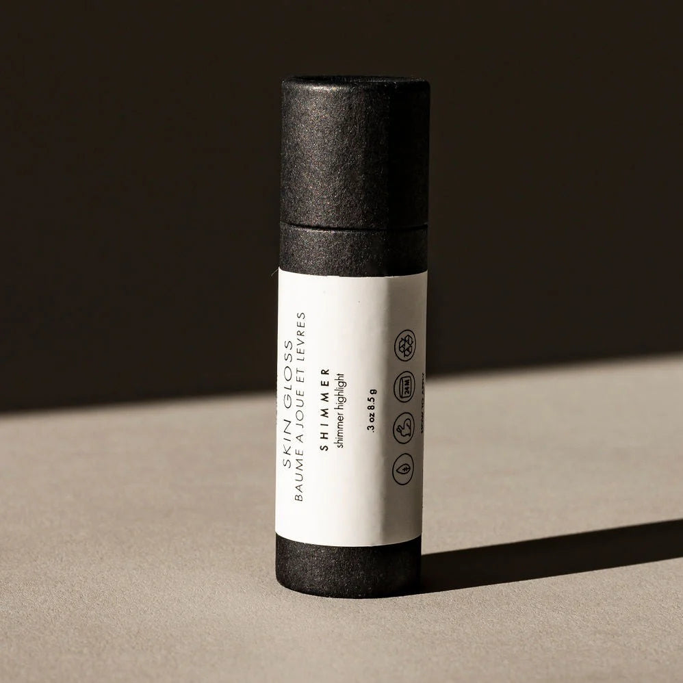 Skincare product tube with black cap and white label on a beige surface