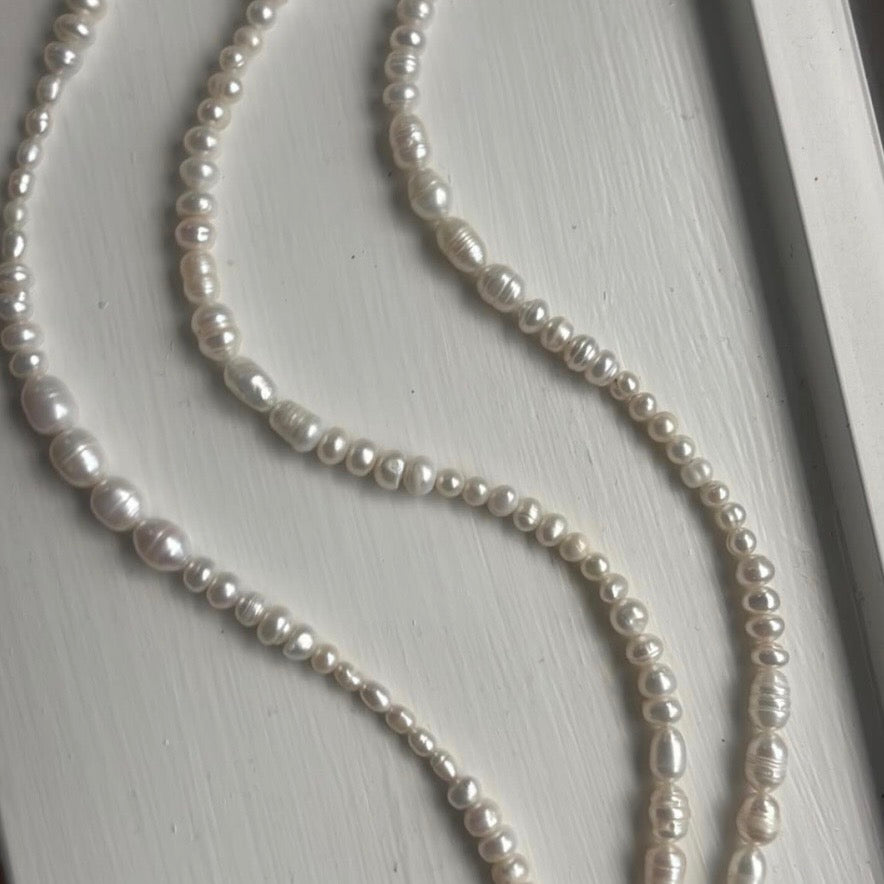 Pearl necklace on a light wooden surface