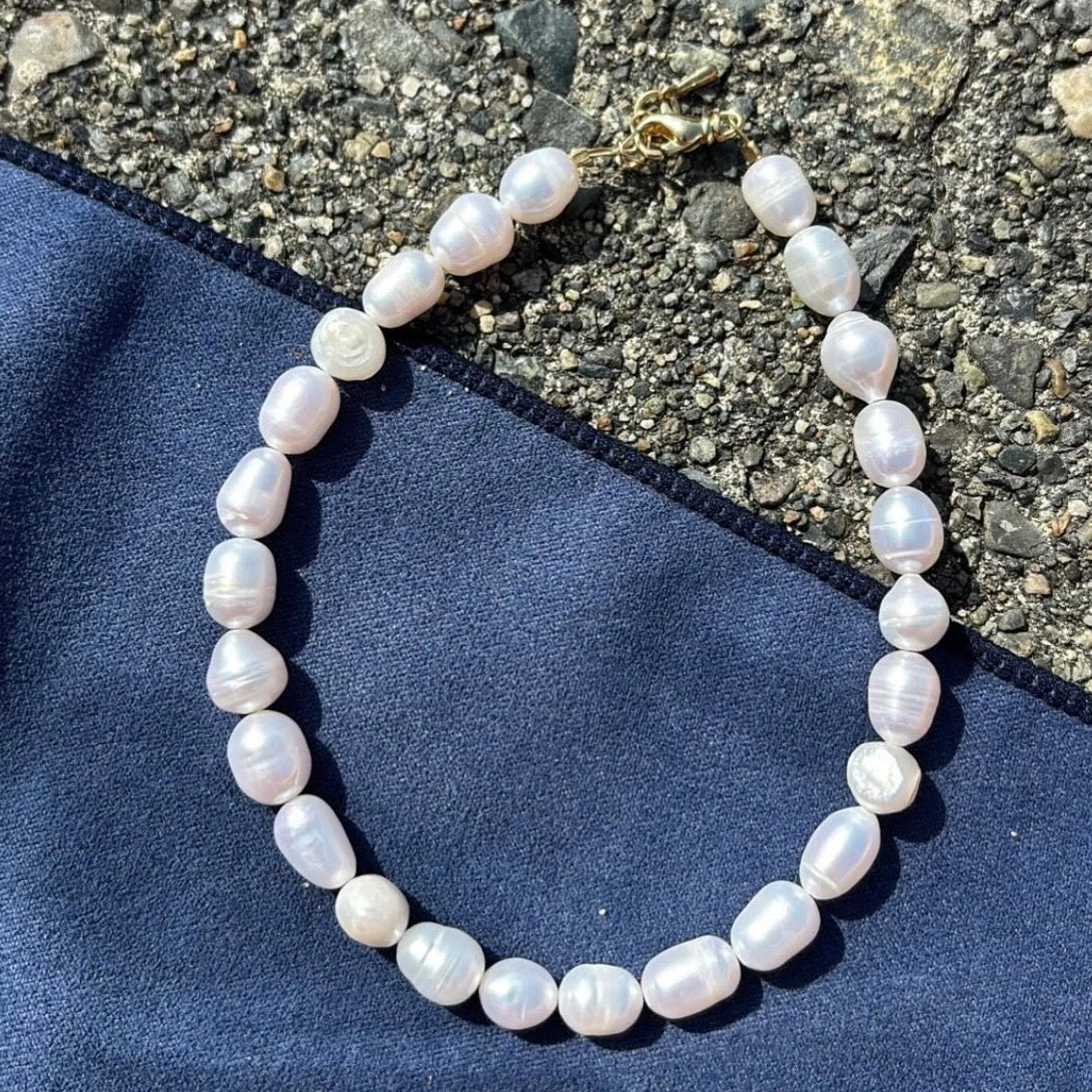 Pearl necklace on a blue fabric background