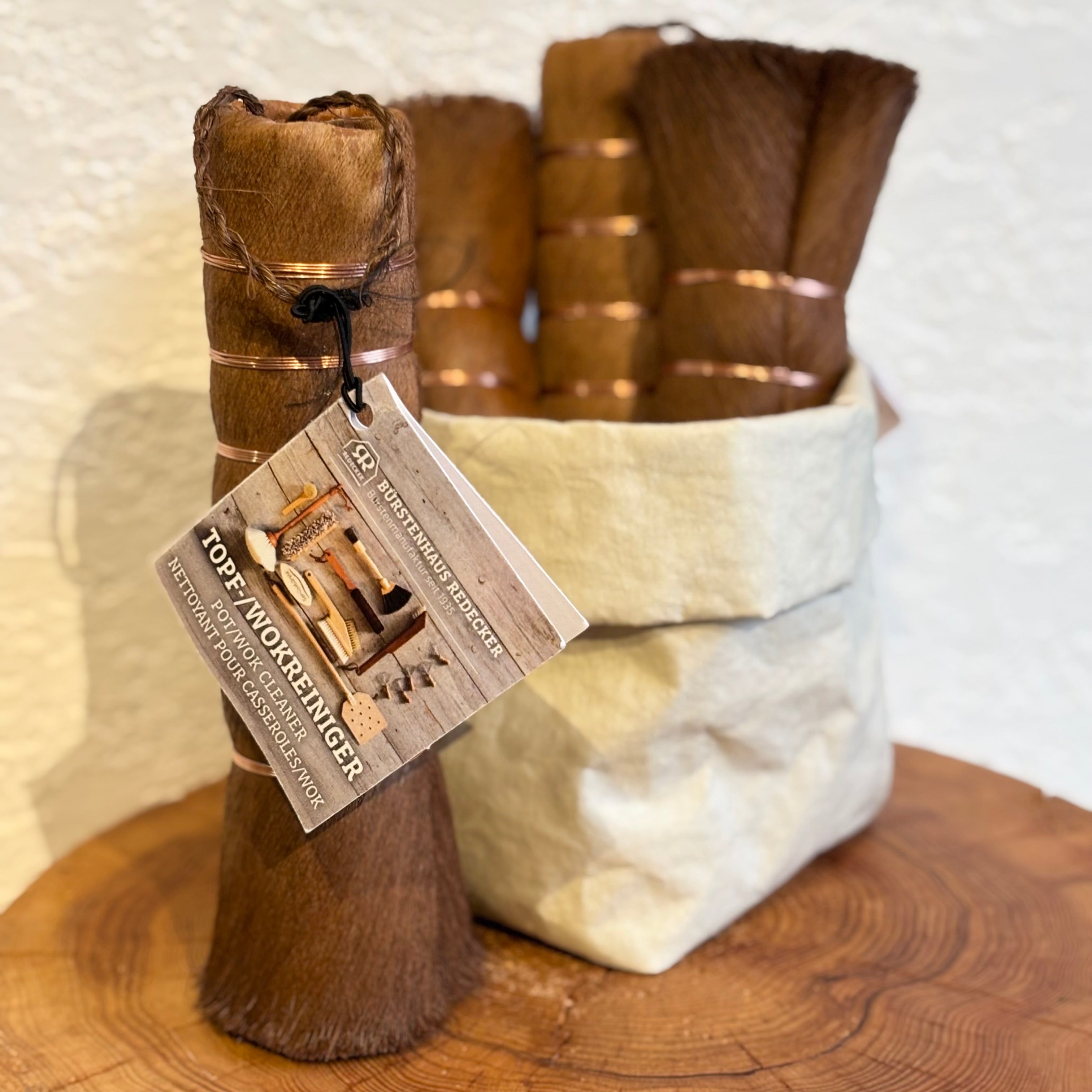 Tall wok cleaner with a tag on a wooden surface