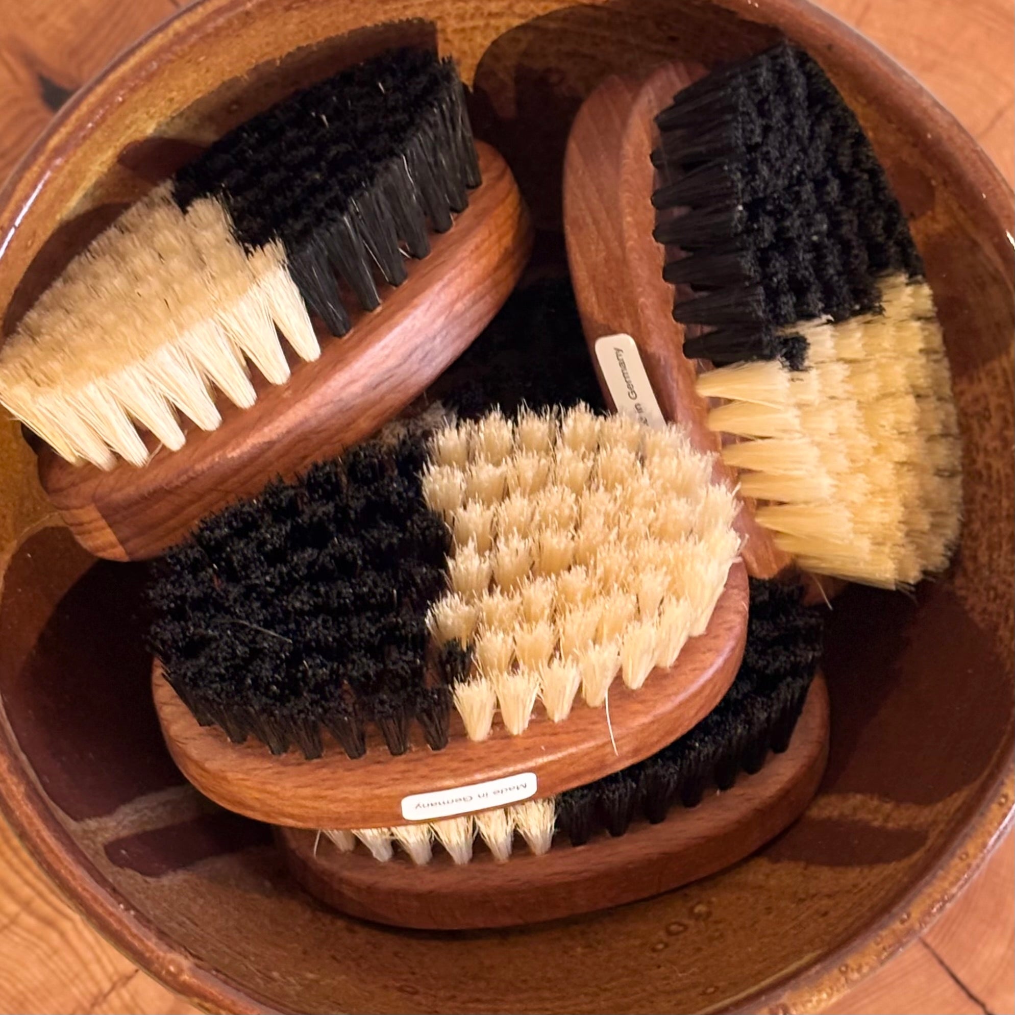 Set of wooden brushes with natural bristles in a wooden holder.