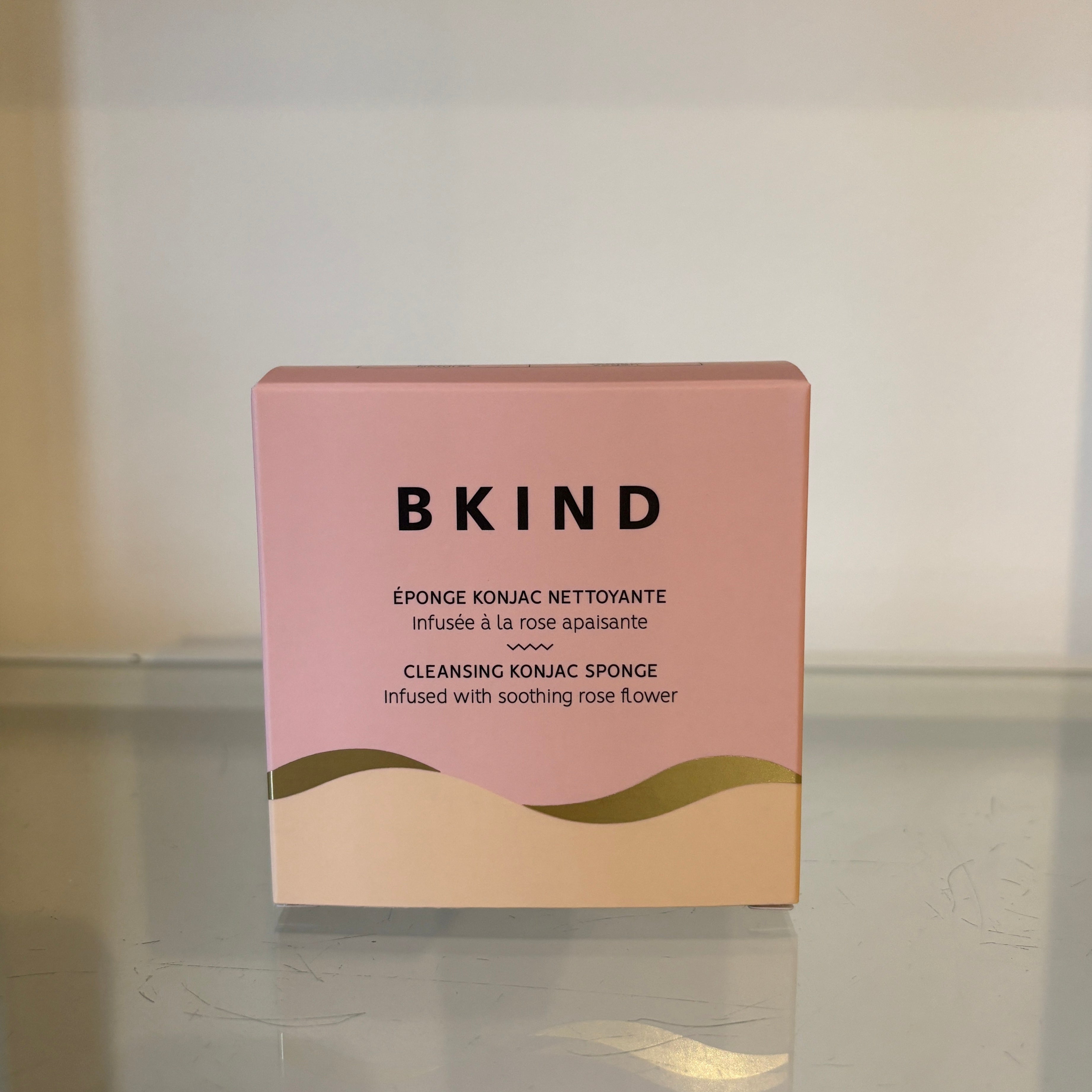 Pink box with 'BKIND' branding on a reflective surface