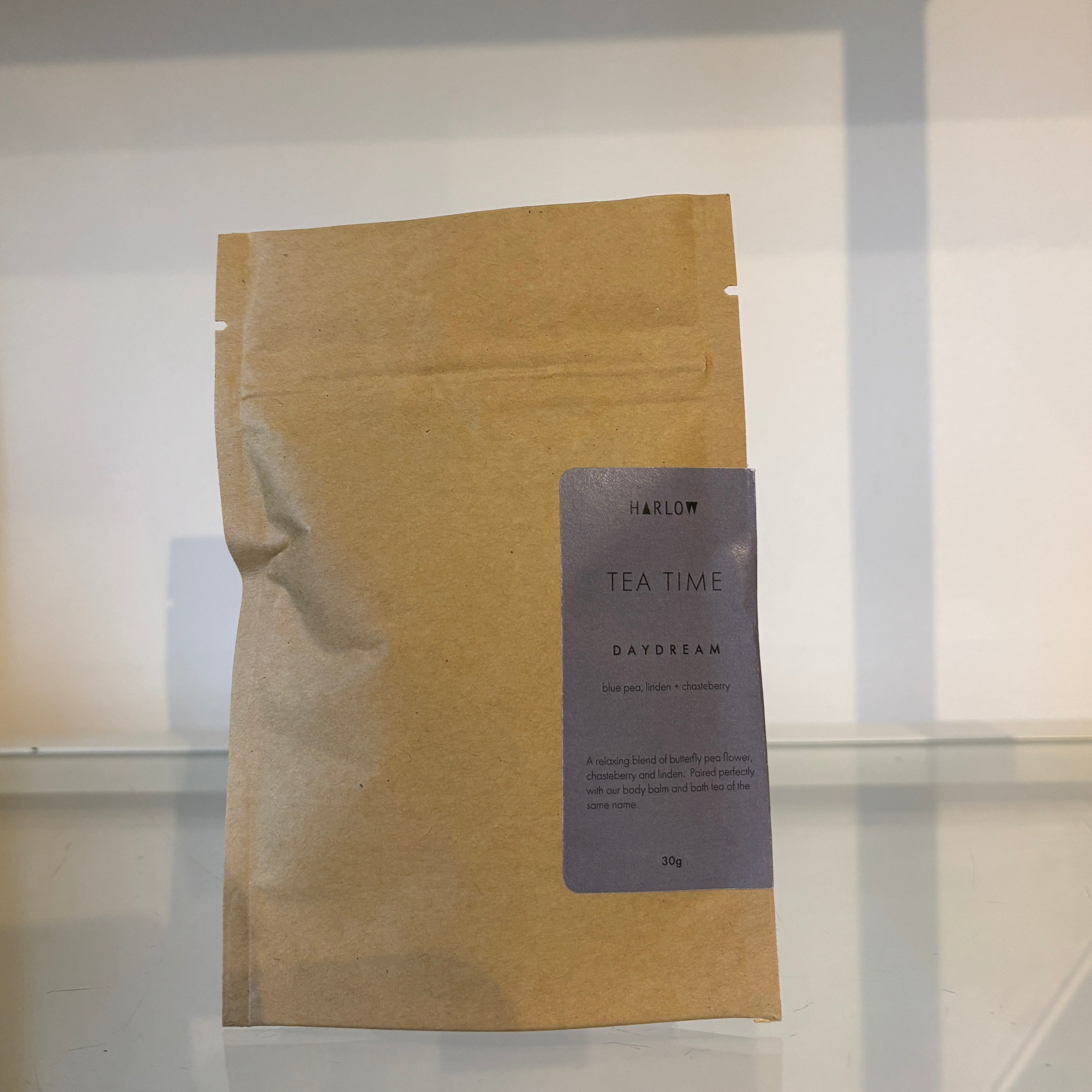 Kraft paper tea bag with a label on a reflective surface