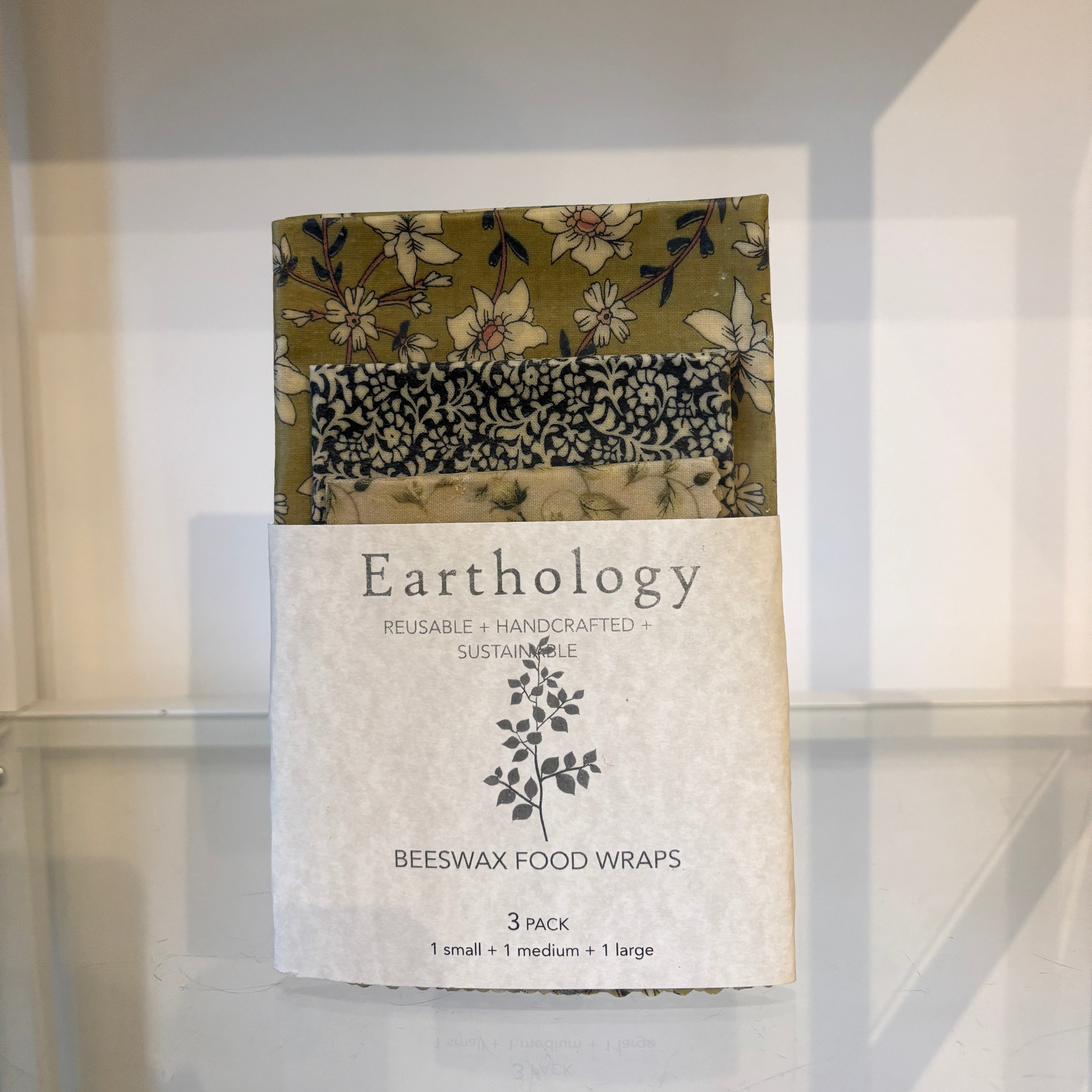 Pack of Earthology beeswax food wraps with floral and patterned designs on a white background.