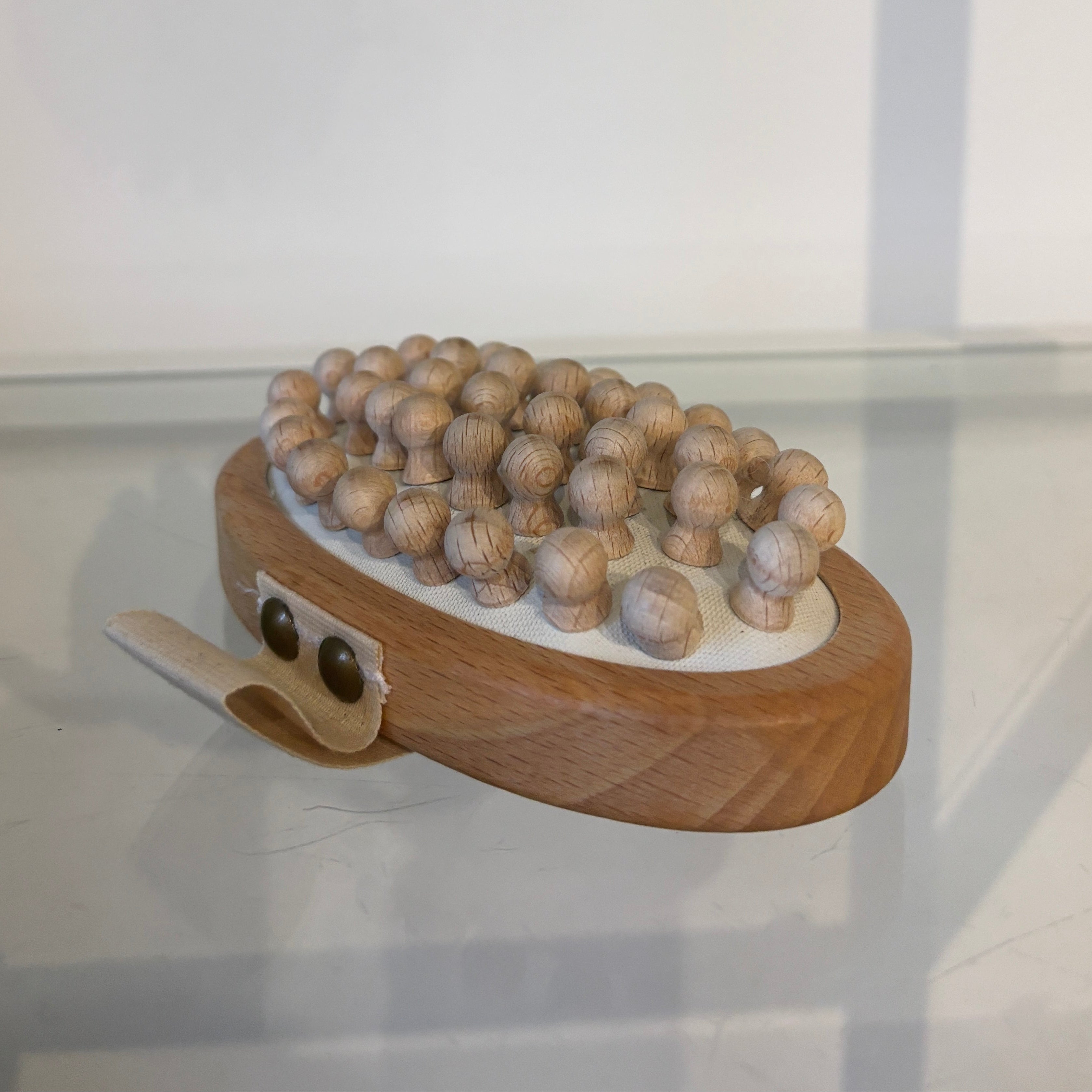 Wooden lymphatic massager with round beads on a white background