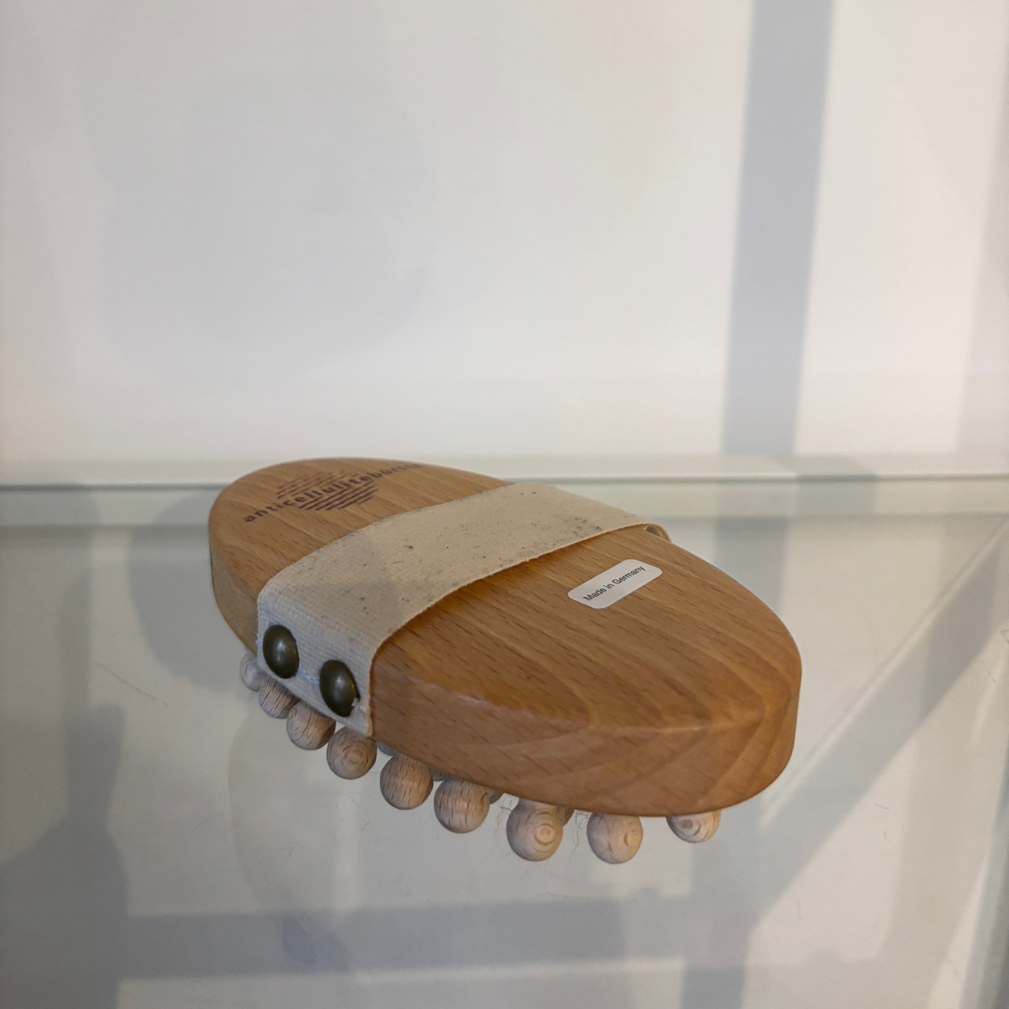 Wooden lymphatic massager on a reflective surface with a white background