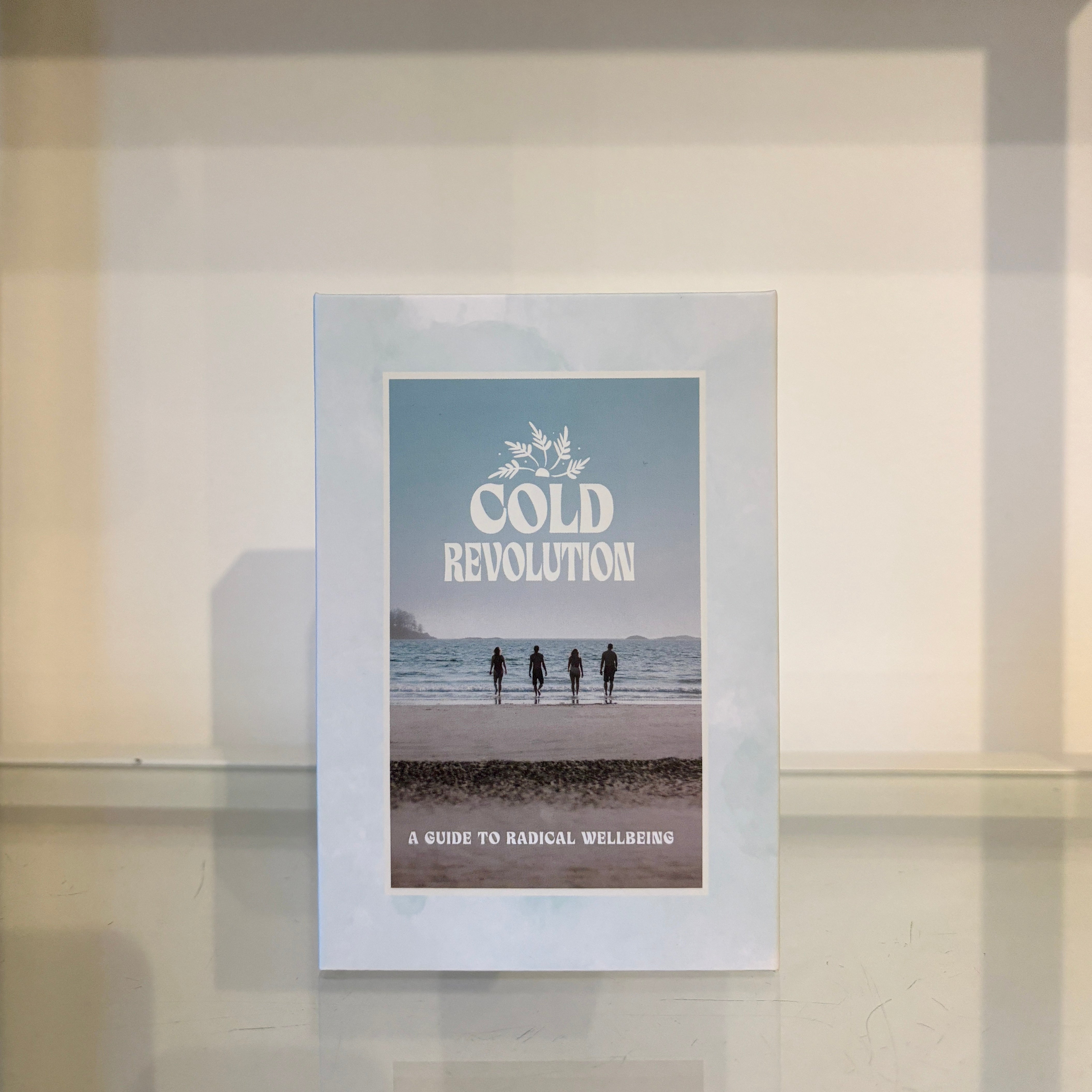 Card deck titled 'Cold Revolution' with a beach scene and text on a glass surface.