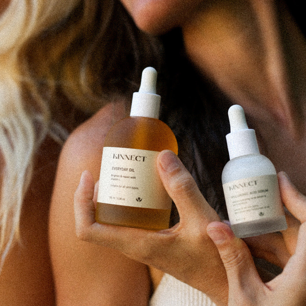 Two people holding bottles of a skincare product with visible branding.