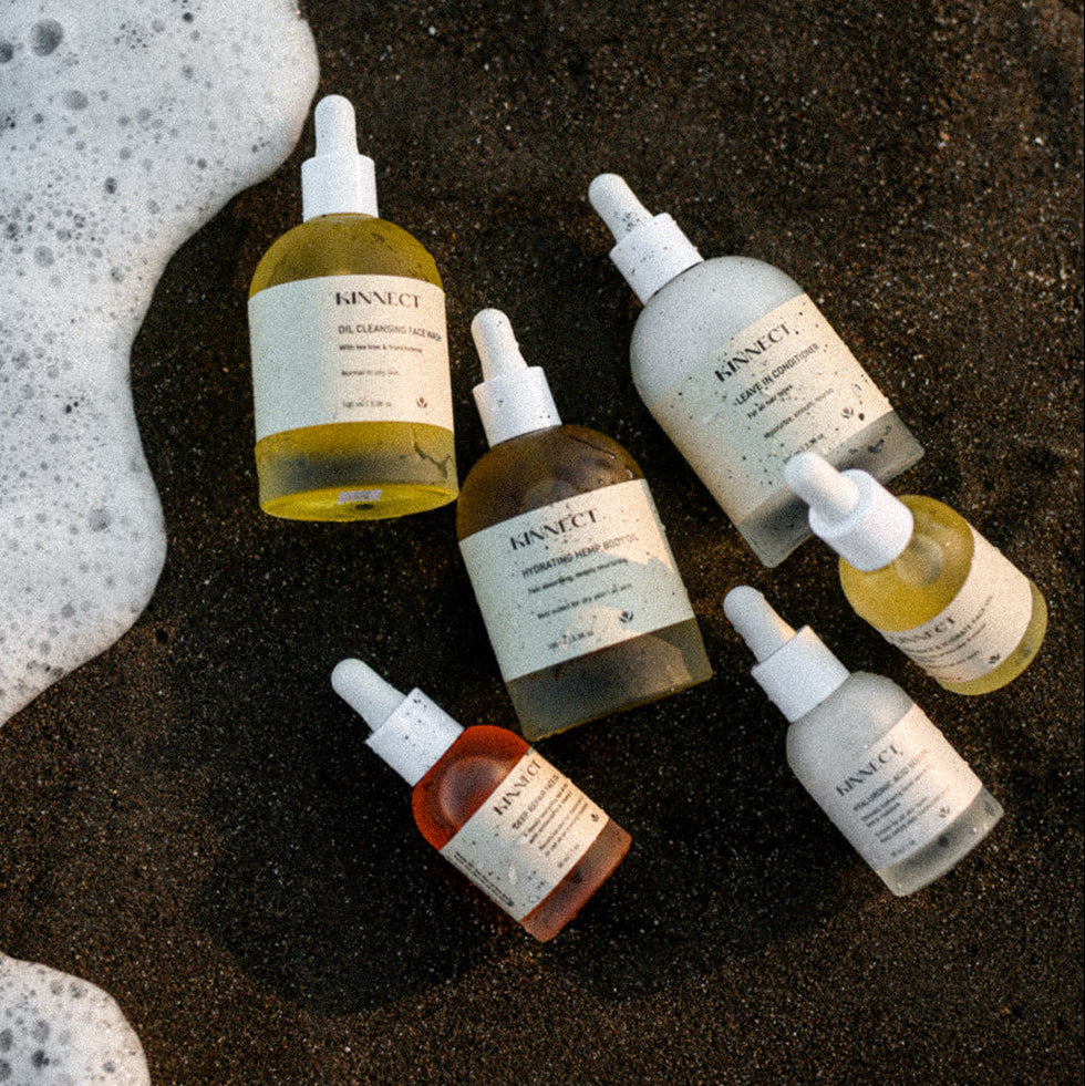 Kinnect skincare products on a beach with ocean foam