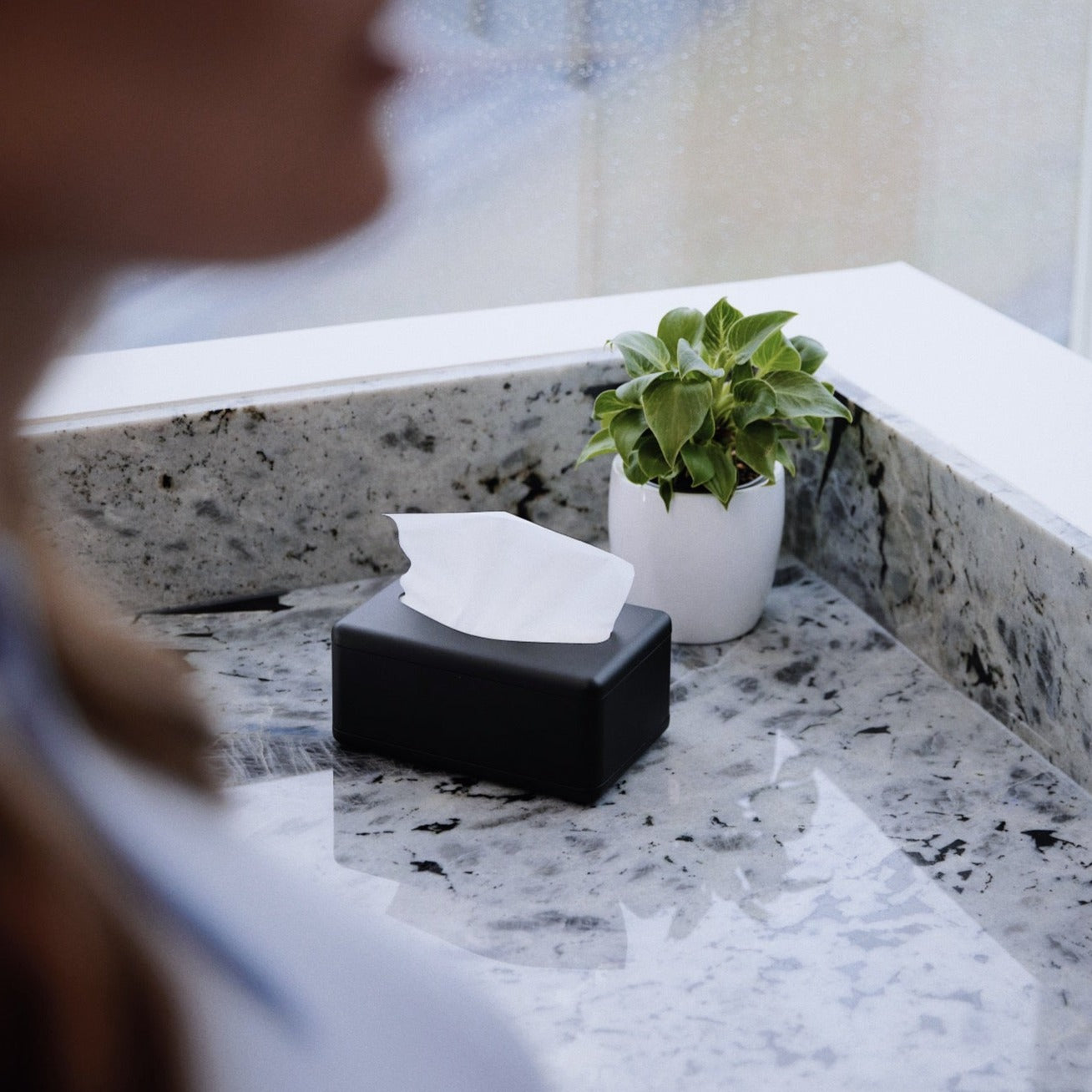 Fox Fold Bamboo Tissue Paper sits ready to be used on a marble counter top in a black Fox Fold Tissue Dispenser
