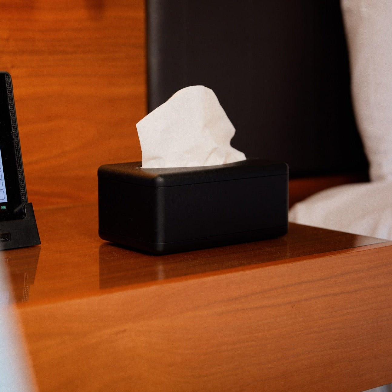 Fox Fold Bamboo Tissue Paper sits ready to be used on a wooden bench in a black Fox fold tissue dispenser