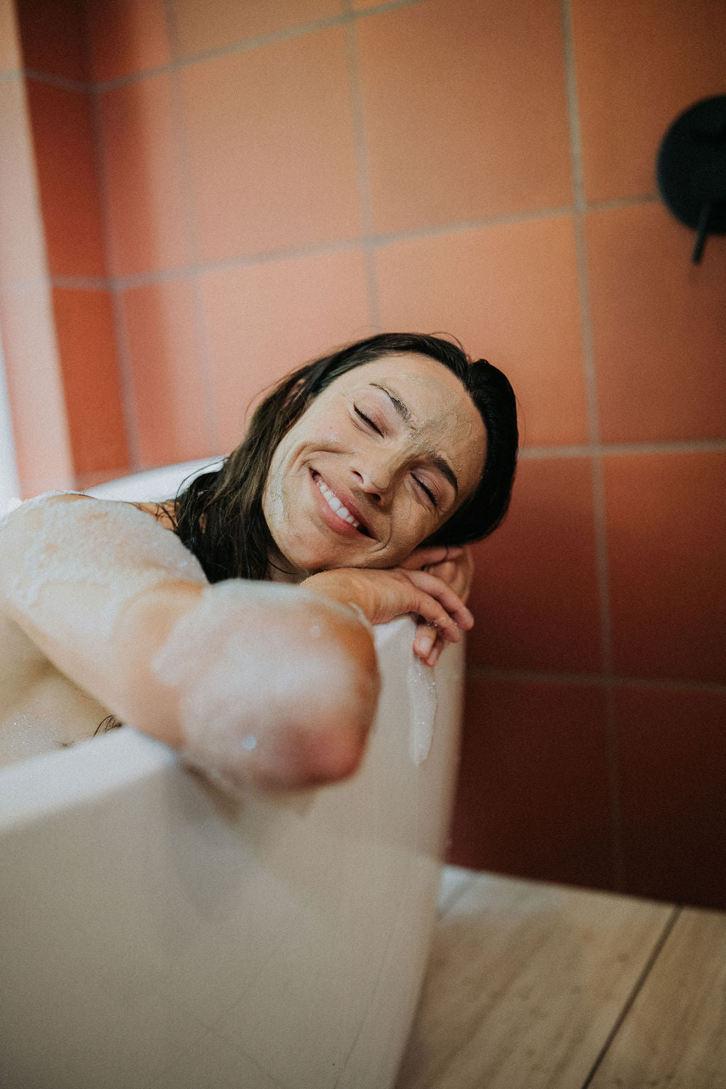 Model smiling and relaxing in bubble bath