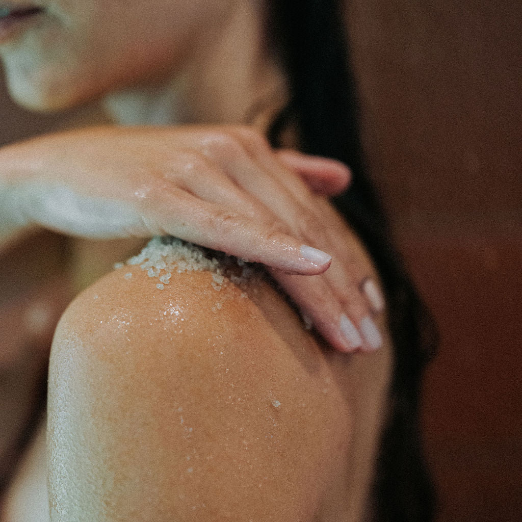 Person with Kinnect body scrub on their shoulder against a blurred background