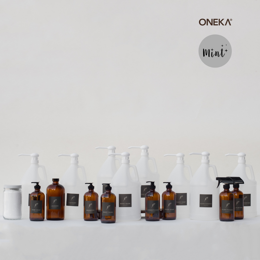 The Den Refillery Refill Everything kit aesthetically organized in front of a white background. There are an assortment of plastic 4 litre jugs, glass jars, and amber glass jars.