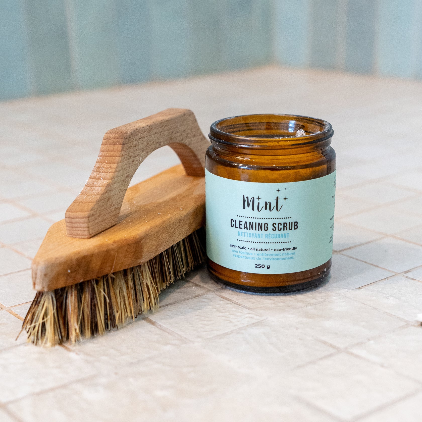 Open Mint Cleaning Scrub jar with Redecker stiff bristle scrub brush for floor washing.