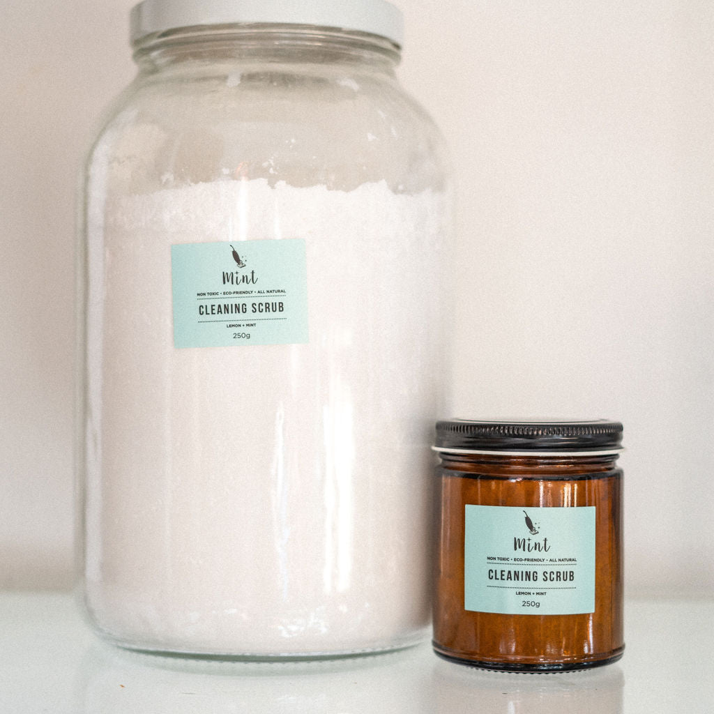 Mint cleaning scrub in small amber glass jar (250g) and large clear glass jar (4kg).