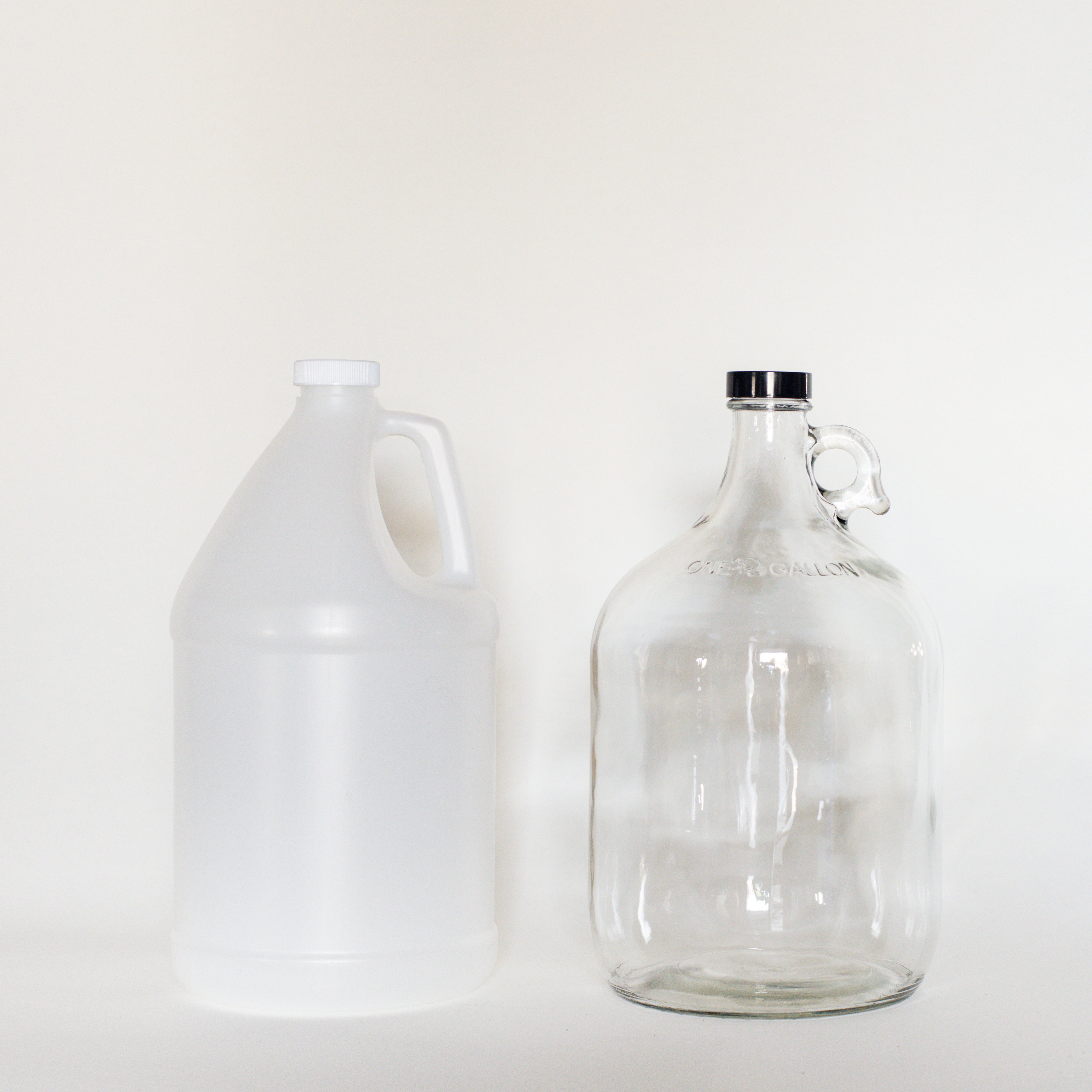 White plastic and clear glass 4 litre growler with white background